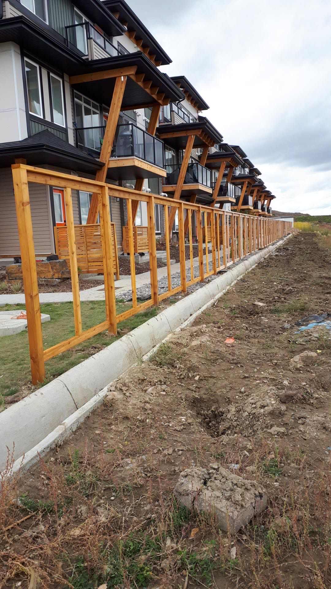 Custom cedar railing run along the front of a new multi-family building