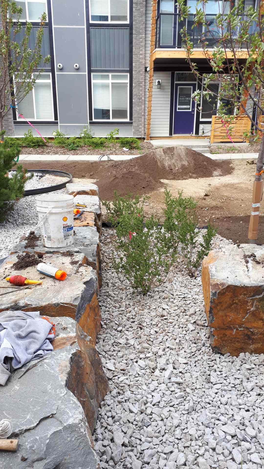 Boulder-lined rock bed along a new townhome entry